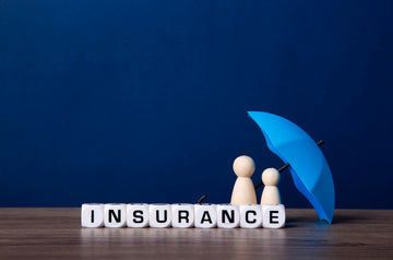 word insurance written on white plastic cubes under a blue mini umbrella