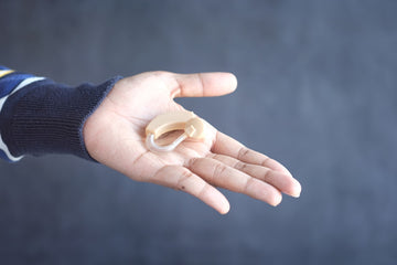 hands showing a hearing aid