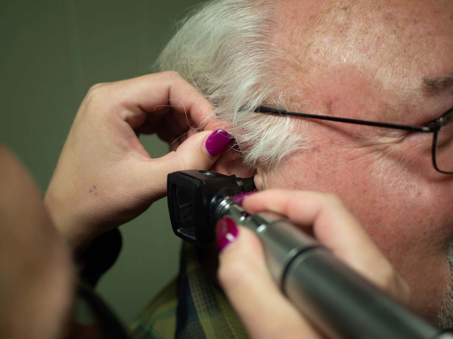 an old man getting his ear examined